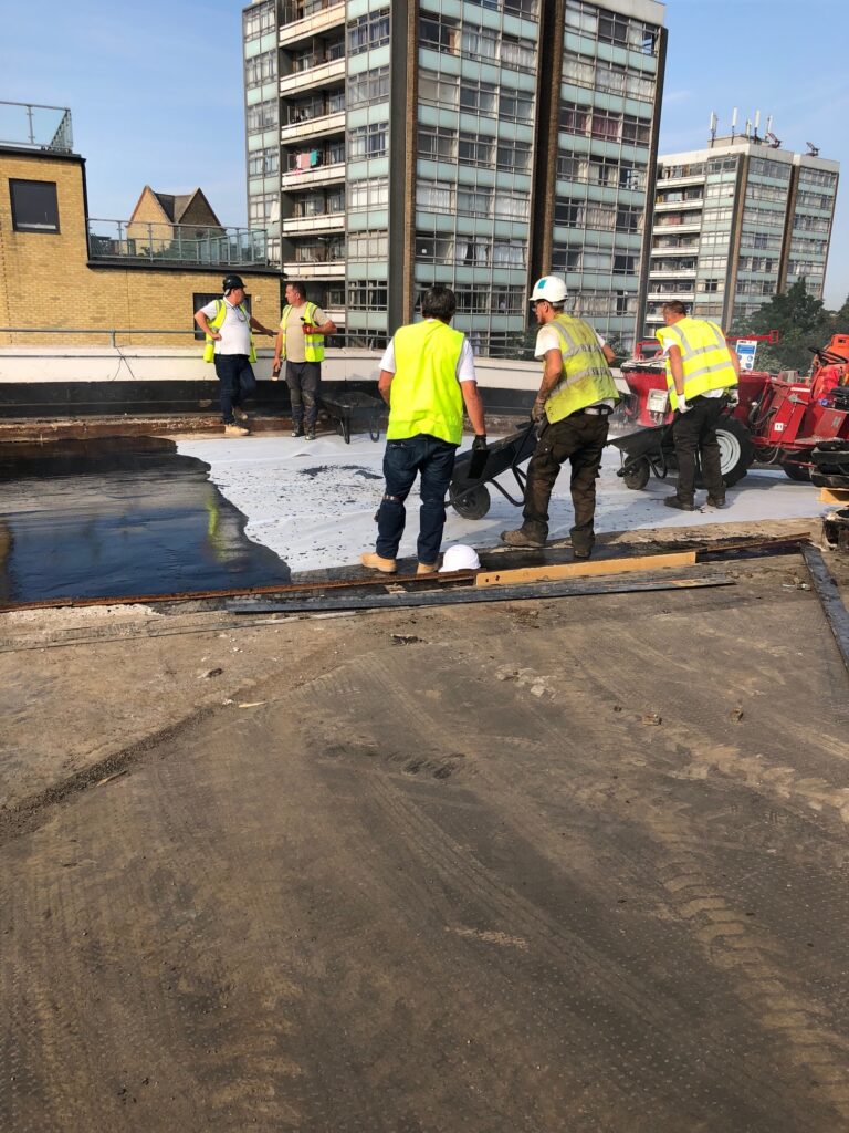 Workmen on a roof working on Mastic Asphalt In The UK